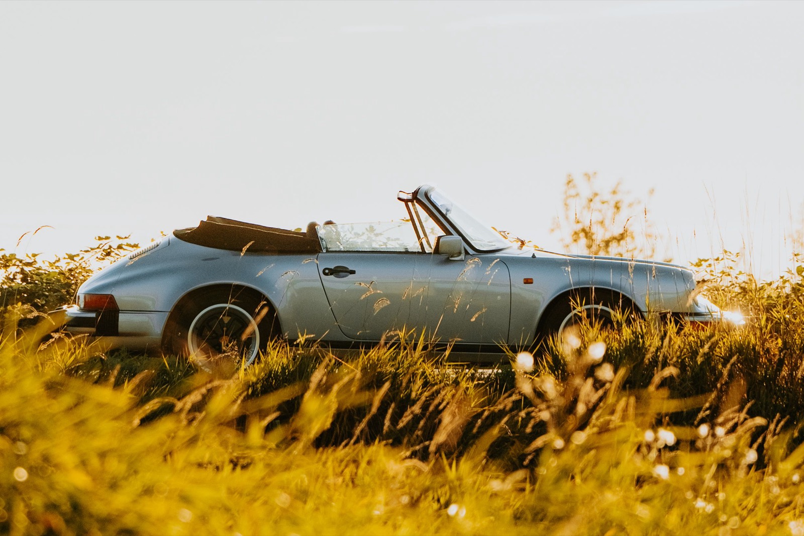 Porsche 911 Cabriolet with its soft top folded down in evening light